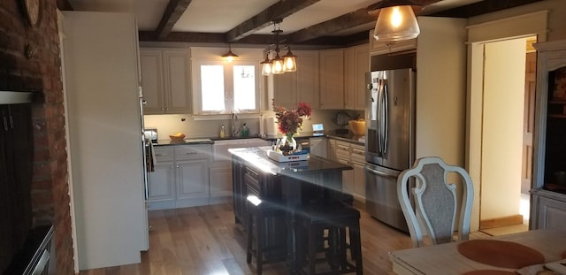 888 Pondview Rd, Riverhead, NY 11901 - kitchen featuring stainless steel fridge, beam ceiling, light hardwood / wood-style floors, a kitchen bar, and decorative light fixtures