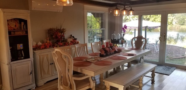 888 Pondview Rd, Riverhead, NY 11901 - dining area featuring a water view, a wall mounted air conditioner, and light hardwood / wood-style floors