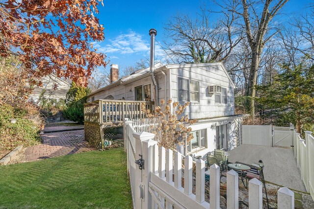 exterior space with a wooden deck and a front yard