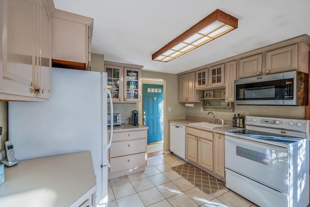 kitchen featuring sink, white appliances, light brown cabinetry, and light tile patterned floors