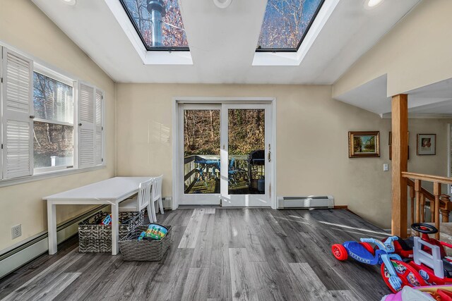 interior space featuring dark hardwood / wood-style floors, lofted ceiling with skylight, and a baseboard radiator