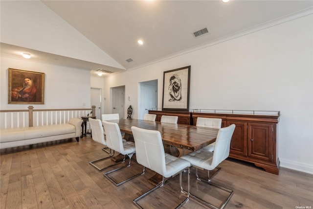 dining space featuring wood-type flooring and high vaulted ceiling