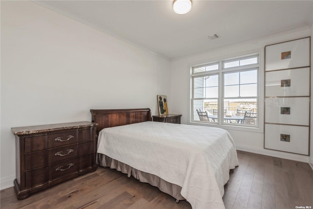 bedroom featuring dark wood-type flooring and ornamental molding