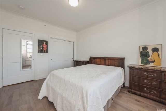 bedroom featuring crown molding, wood-type flooring, and a closet