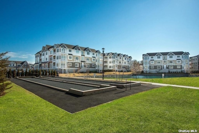 view of community featuring a water view and a yard