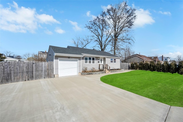 ranch-style home featuring a front yard, driveway, an attached garage, and fence