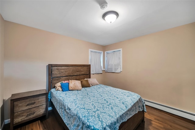 bedroom with a baseboard radiator and dark wood finished floors