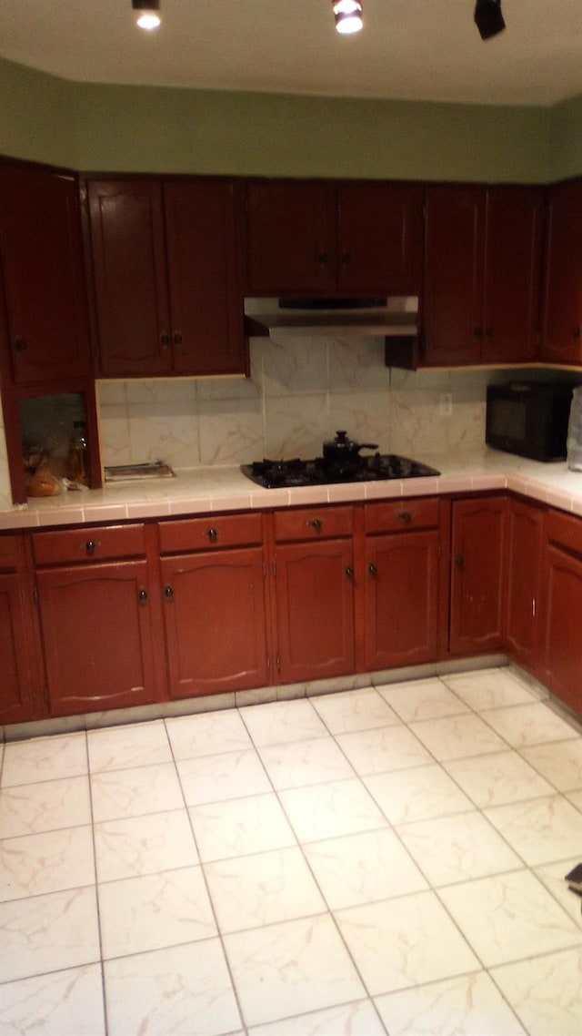 kitchen featuring tasteful backsplash and black appliances