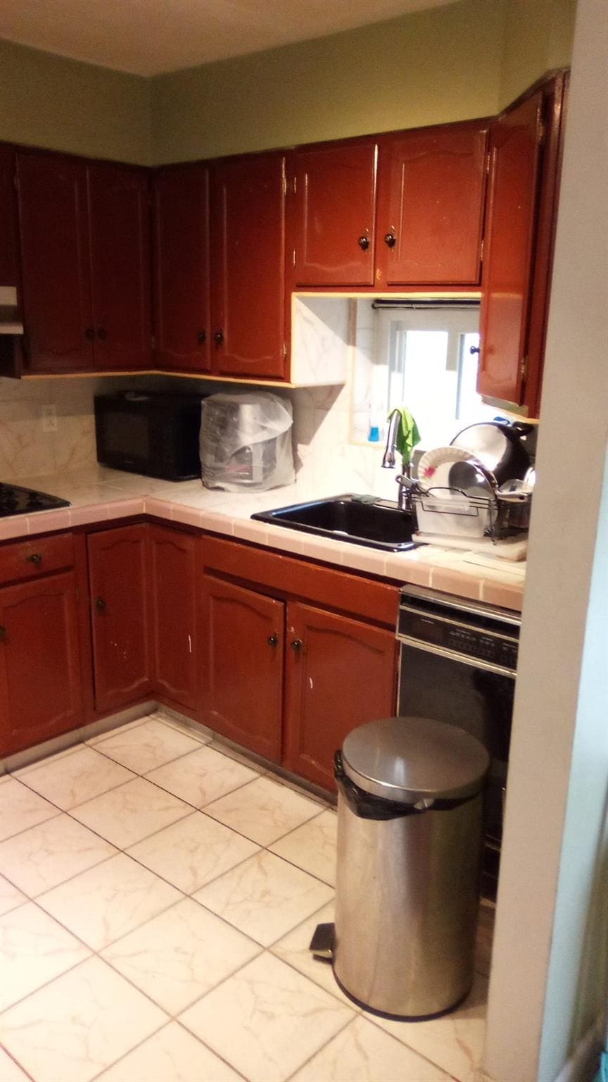 kitchen with extractor fan, sink, decorative backsplash, and black appliances