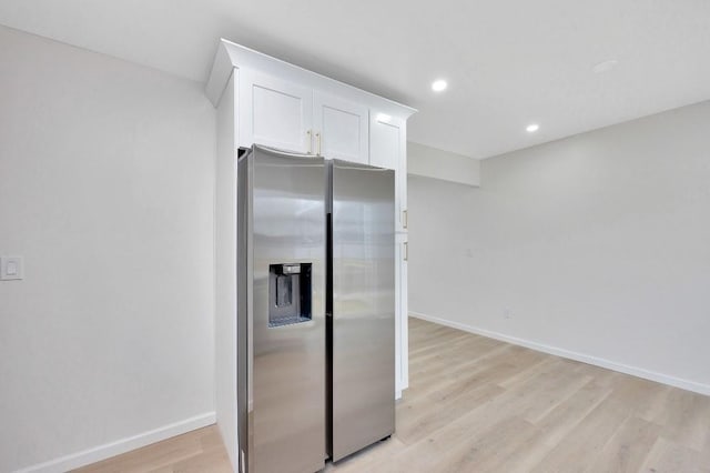 kitchen featuring stainless steel refrigerator with ice dispenser, white cabinetry, and light hardwood / wood-style flooring