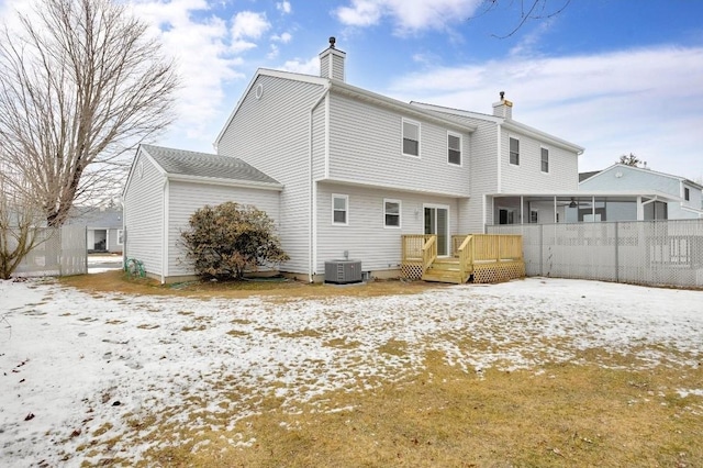 snow covered property with a wooden deck and central air condition unit