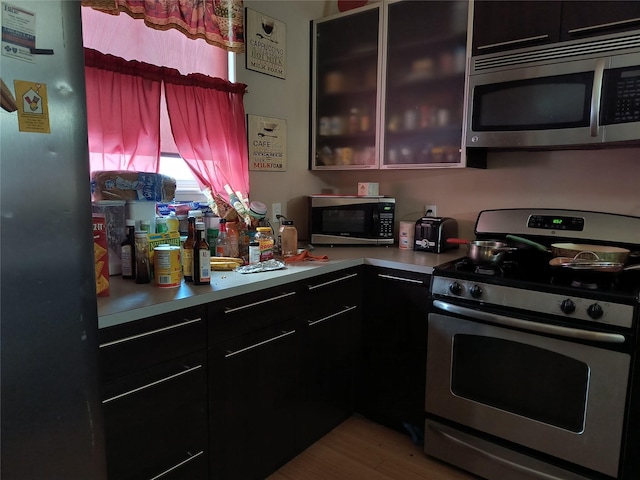 kitchen with appliances with stainless steel finishes and light hardwood / wood-style flooring