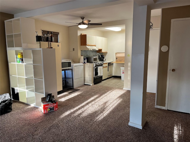 kitchen featuring tasteful backsplash, range with gas cooktop, under cabinet range hood, washer / clothes dryer, and stainless steel dishwasher