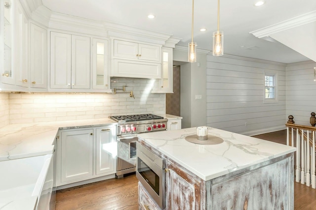 kitchen with white cabinetry, hanging light fixtures, stainless steel appliances, and light stone counters