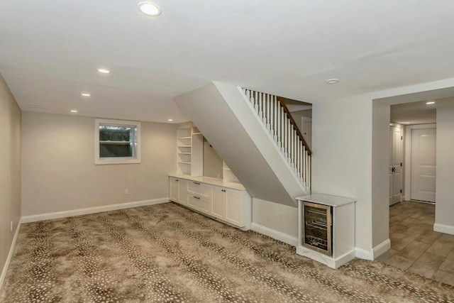 additional living space featuring wine cooler and light hardwood / wood-style floors