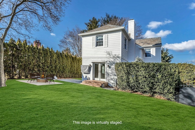 rear view of property featuring a patio and a lawn