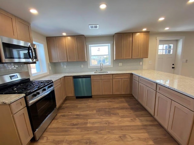 kitchen featuring sink, stainless steel appliances, wood-type flooring, kitchen peninsula, and light brown cabinets