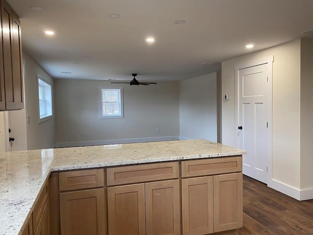 kitchen featuring light stone counters, dark hardwood / wood-style flooring, and ceiling fan