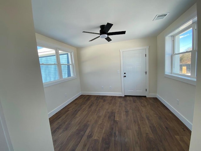 spare room featuring ceiling fan, a healthy amount of sunlight, and dark hardwood / wood-style floors