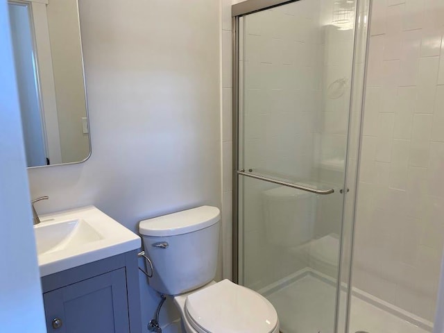 bathroom with an enclosed shower, vanity, and toilet