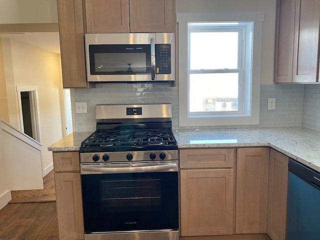 kitchen featuring hardwood / wood-style floors, light brown cabinets, light stone countertops, and appliances with stainless steel finishes