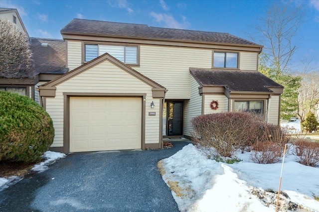 view of front of house with a shingled roof and aphalt driveway