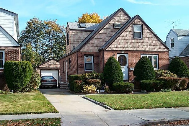 view of front of home featuring a garage, an outbuilding, and a front yard