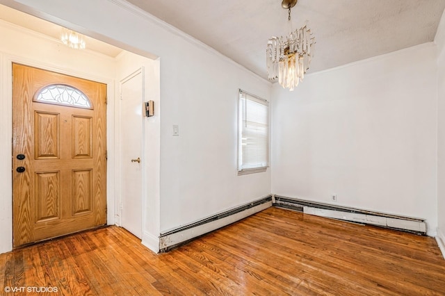 entryway with a notable chandelier, crown molding, and hardwood / wood-style flooring