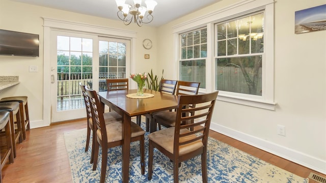 dining space featuring hardwood / wood-style flooring and a chandelier