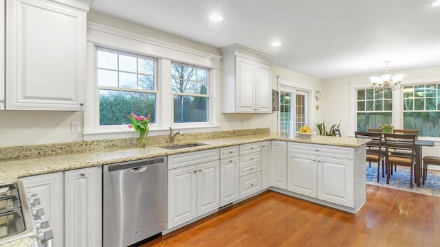 kitchen featuring sink, white cabinets, stainless steel dishwasher, range, and kitchen peninsula