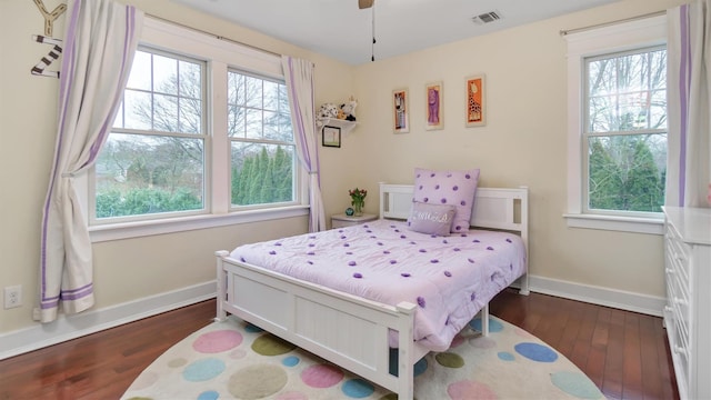 bedroom with dark hardwood / wood-style flooring and multiple windows