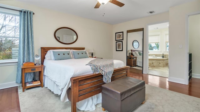 bedroom featuring connected bathroom, hardwood / wood-style floors, and ceiling fan