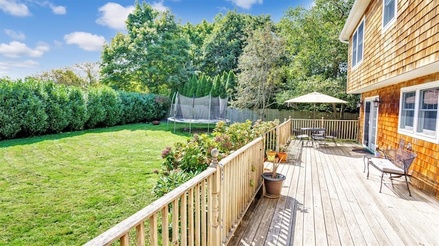 wooden terrace featuring a yard and a trampoline