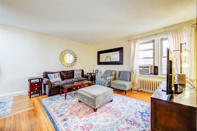 living room featuring radiator, cooling unit, and light wood-type flooring