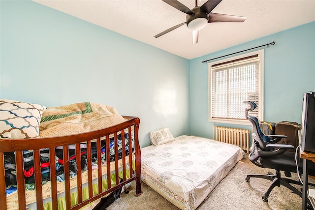 carpeted bedroom with radiator, a textured ceiling, and ceiling fan