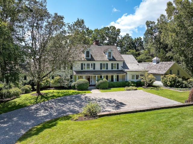 view of front of house featuring a porch, driveway, and a front yard