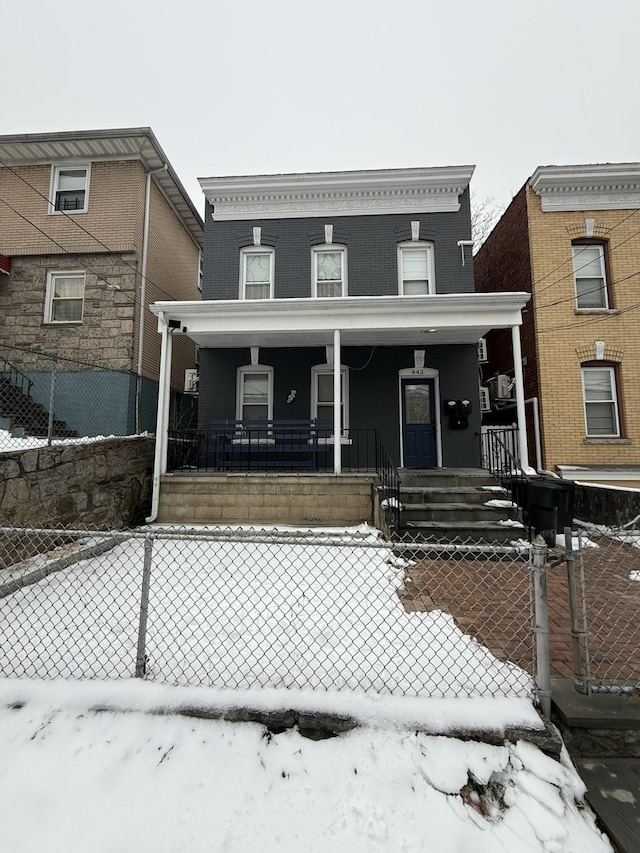 snow covered rear of property with a porch