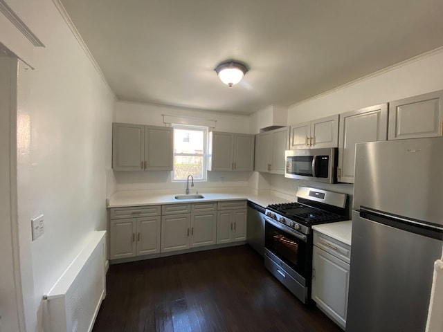 kitchen featuring sink, gray cabinets, stainless steel appliances, dark hardwood / wood-style floors, and ornamental molding