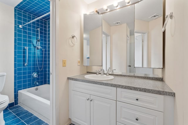 full bathroom featuring vanity, tiled shower / bath, tile patterned flooring, and toilet