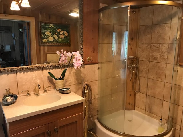 bathroom with a shower stall, decorative backsplash, tile walls, and vanity