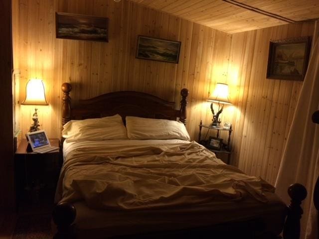 bedroom with wooden ceiling and wooden walls