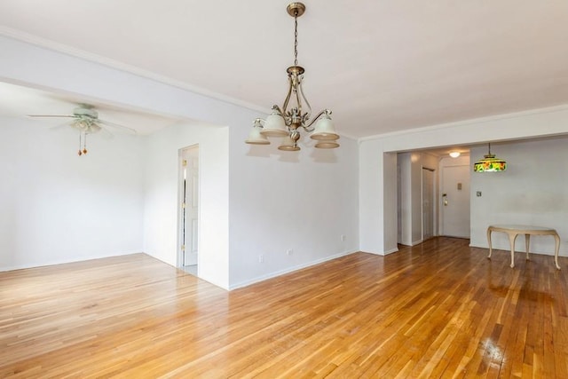 empty room with crown molding, wood-type flooring, and ceiling fan with notable chandelier