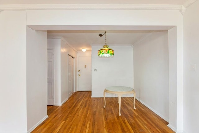 corridor featuring hardwood / wood-style flooring and crown molding