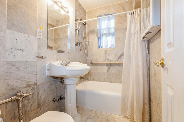 bathroom with toilet, shower / bath combo with shower curtain, and tile walls