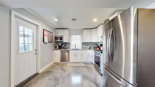 kitchen featuring visible vents, a sink, stainless steel appliances, white cabinetry, and backsplash