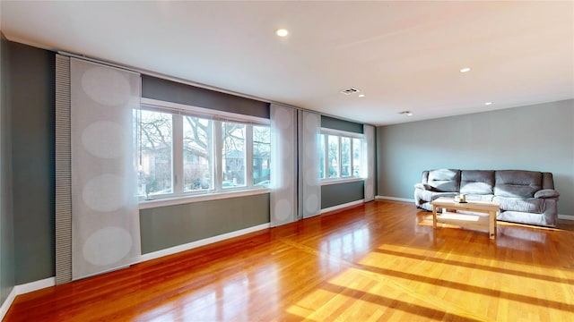 living room with recessed lighting, wood finished floors, visible vents, and baseboards