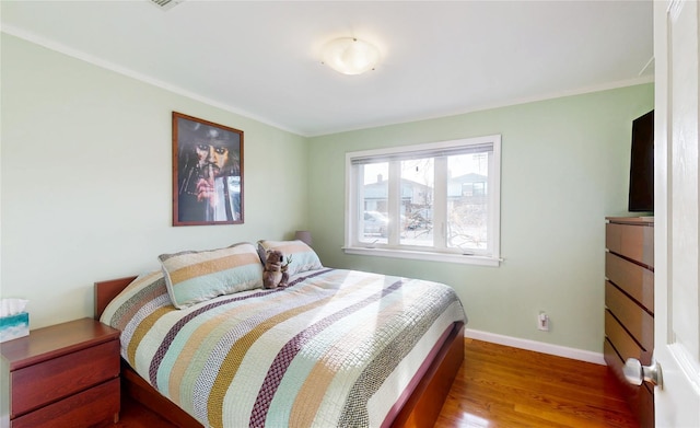 bedroom featuring baseboards and wood finished floors