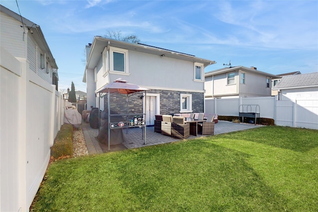 rear view of house featuring an outdoor hangout area, a patio, a lawn, and a fenced backyard