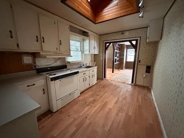 kitchen featuring electric stove, light countertops, and wallpapered walls