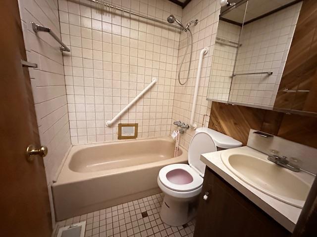 bathroom featuring shower / washtub combination, vanity, toilet, and tile patterned floors